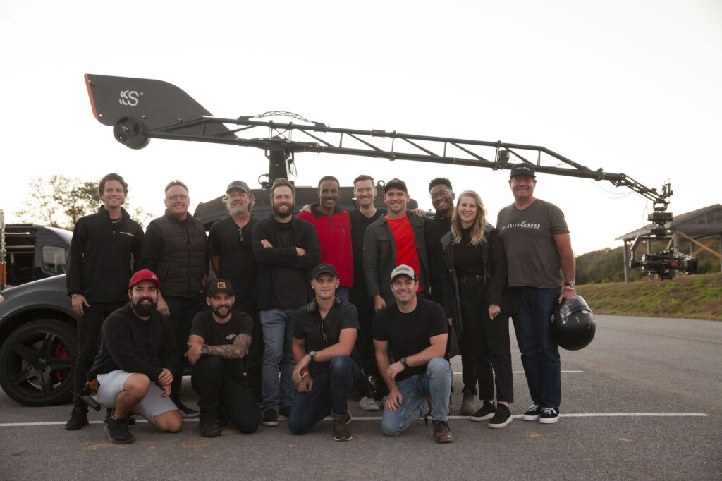 Corry Wiens posing with crew in front of car